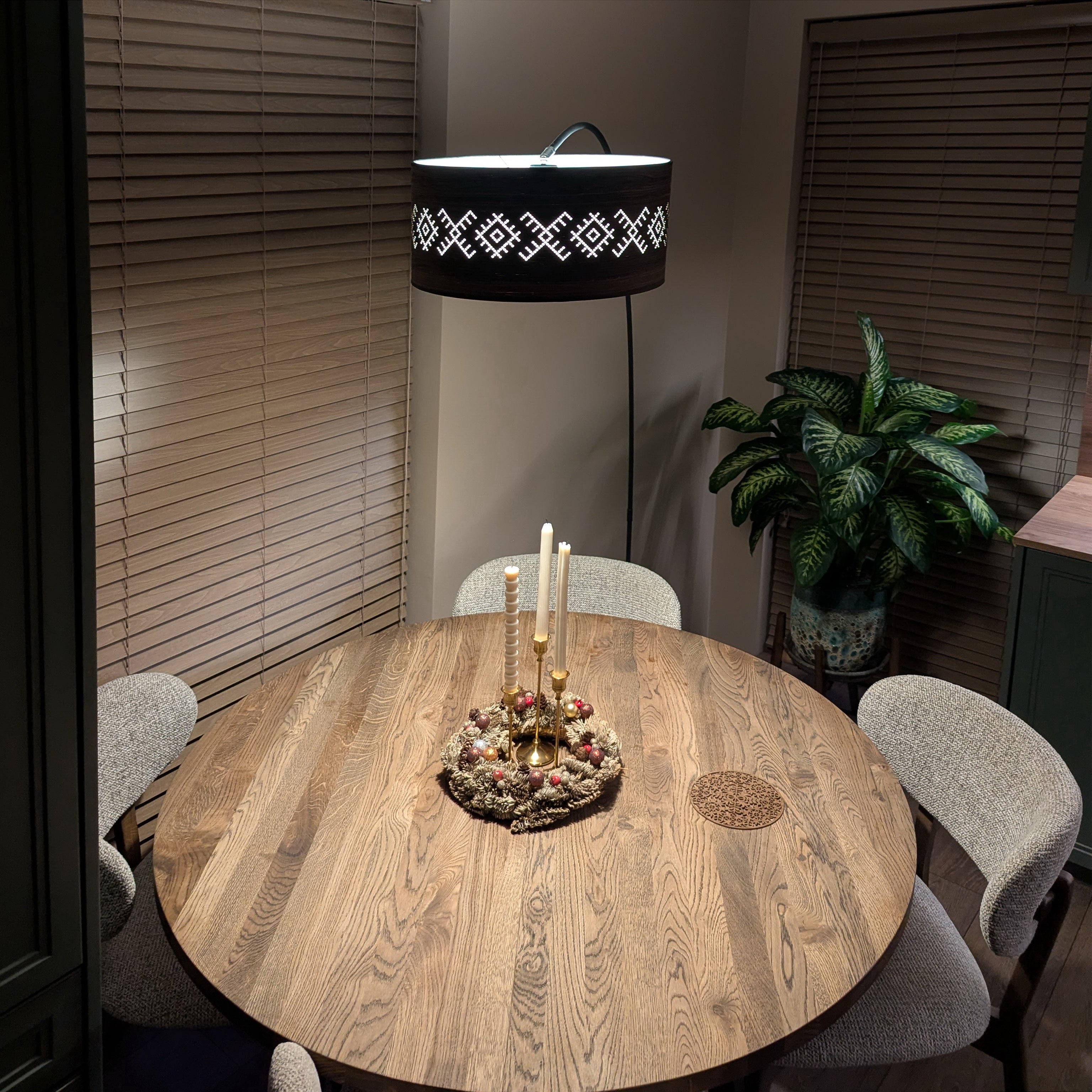 arkos formos pastatomas šviestuvas su gaubtu KUPOLE virš medinio stalo su Kalėdine puokšte